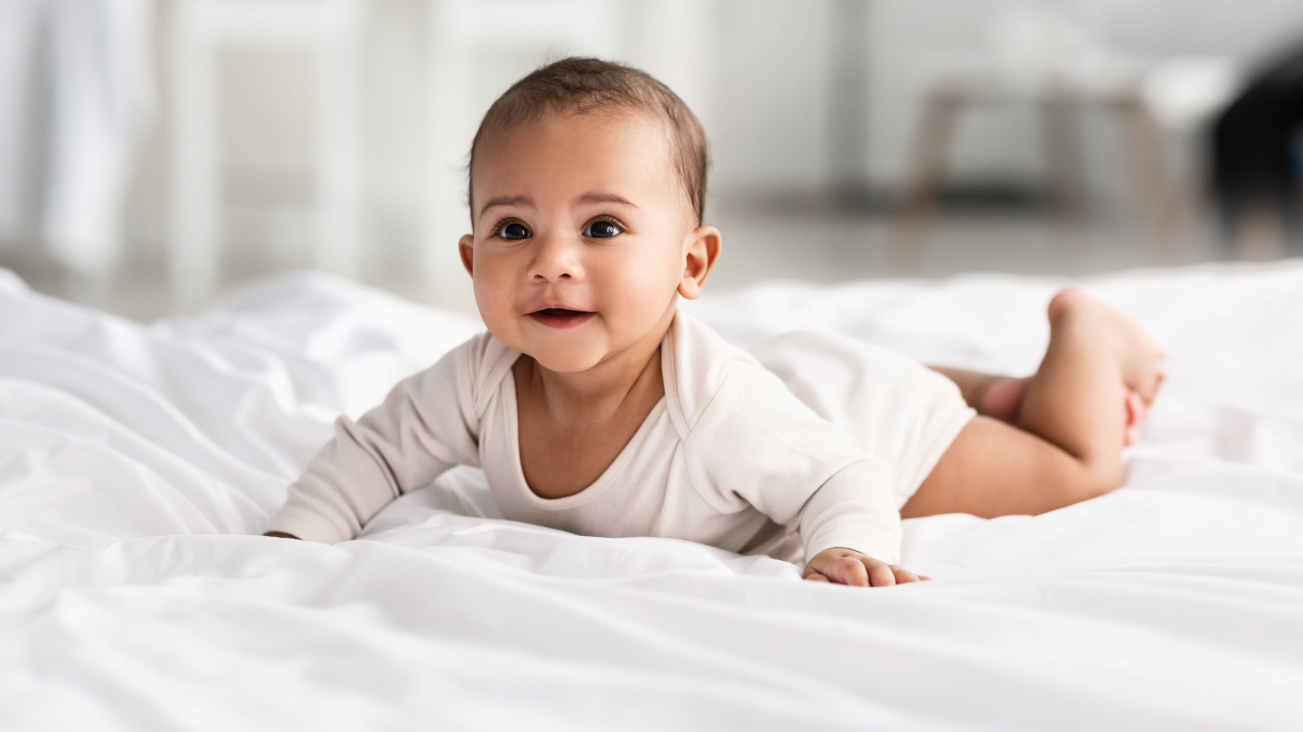 infant lying on stomach on blanket